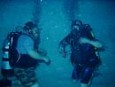 Two divers practicing sharing air while underwater